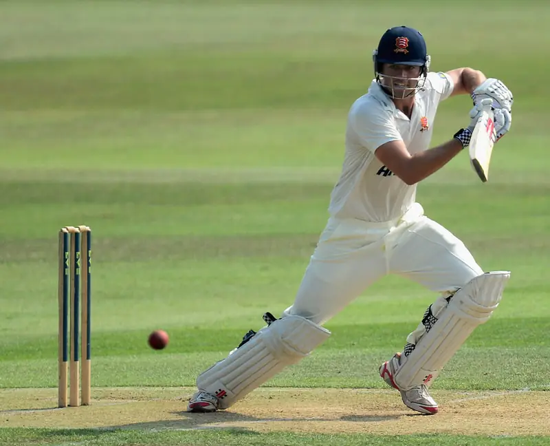 Batsman hitting a cricket ball high during a match