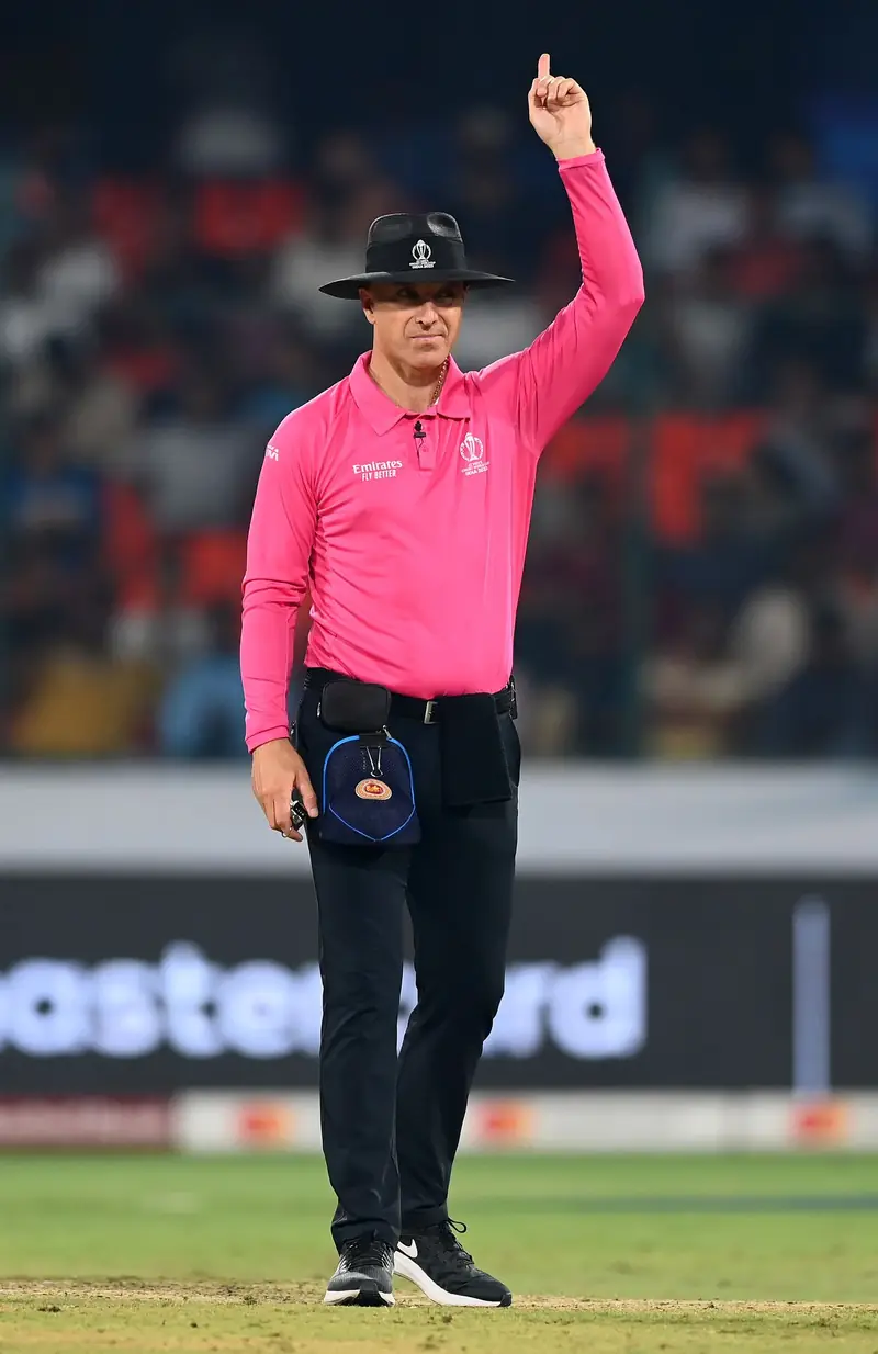Cricket umpire raising his finger to give a batter out LBW